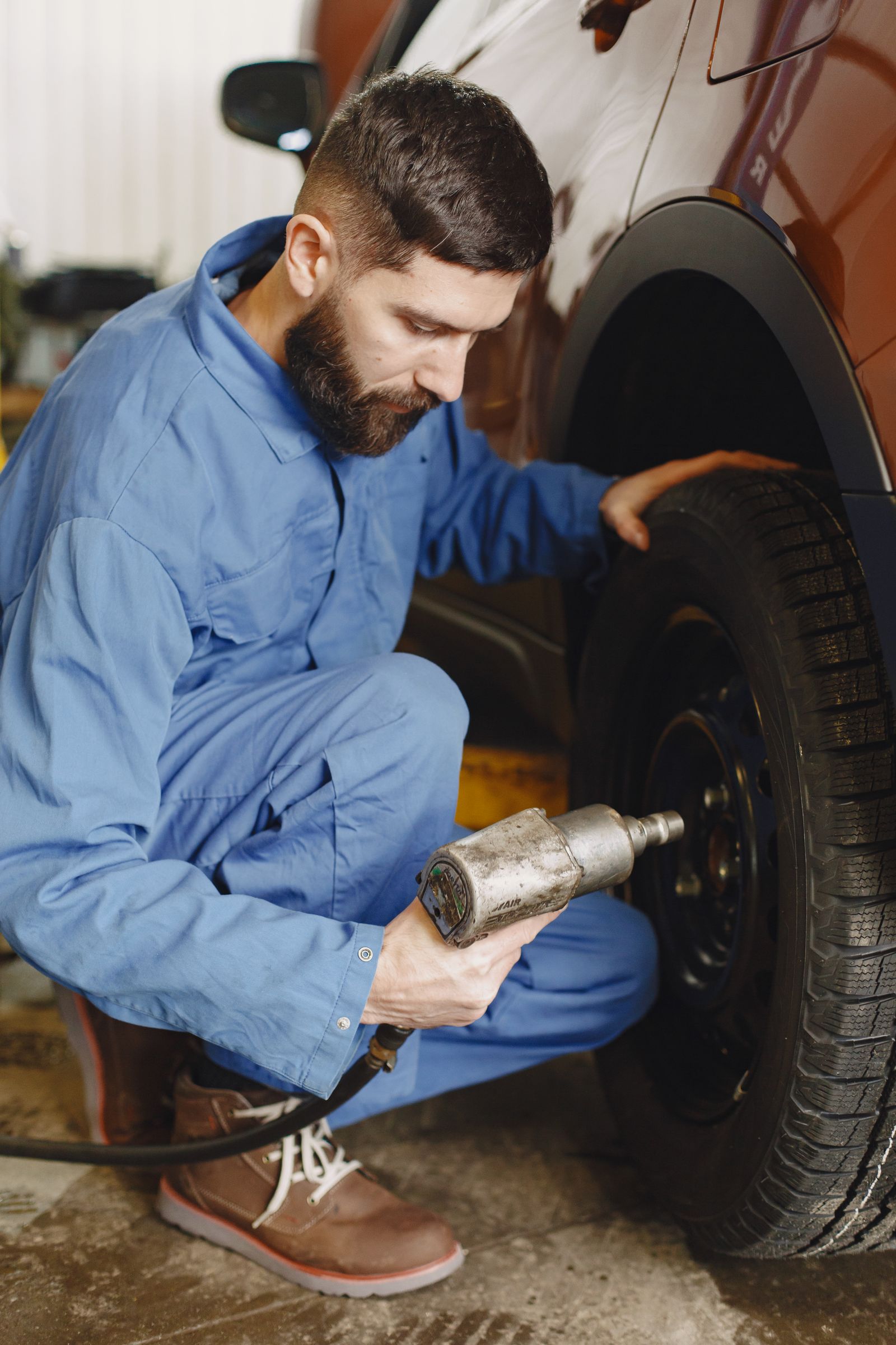 Mechanic using an impact wrench on a wheel